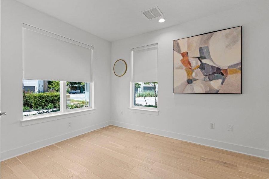 First-floor bedroom with en-suite bath. Hardwood floors and ample natural light define this inviting, minimalist space. First-floor bedroom with en-suite bath. Hardwood floors and ample natural light define this inviting, minimalist space.