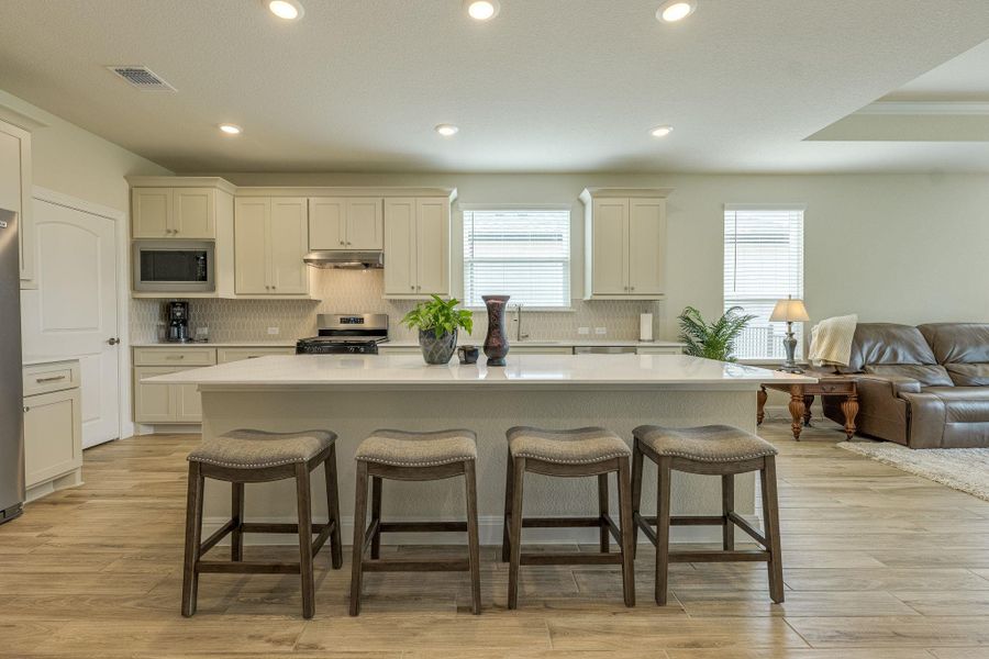 Kitchen featuring a breakfast bar area, a kitchen island, tasteful backsplash, stainless steel appliances, and recessed lighting