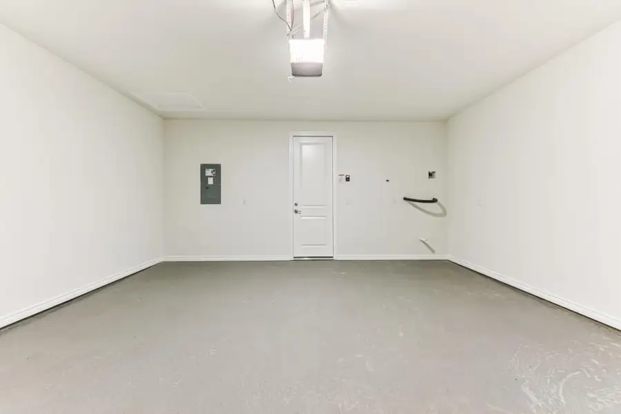 Garage featuring electric panel and a garage door opener Garage featuring electric panel and a garage door opener