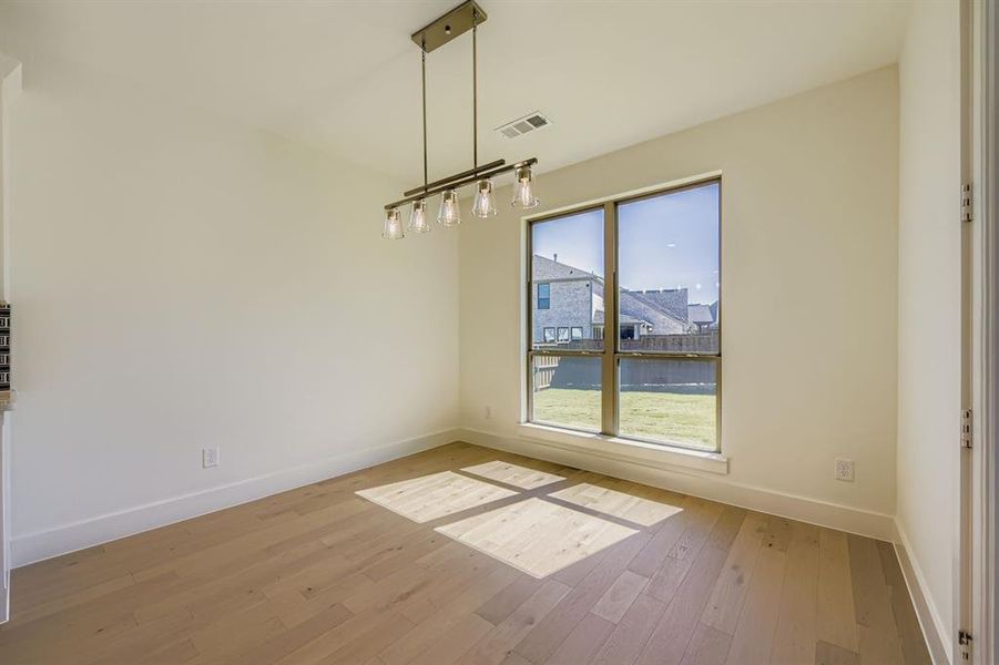 Unfurnished dining area featuring light wood-style floors and baseboards Unfurnished dining area featuring light wood-style floors and baseboards