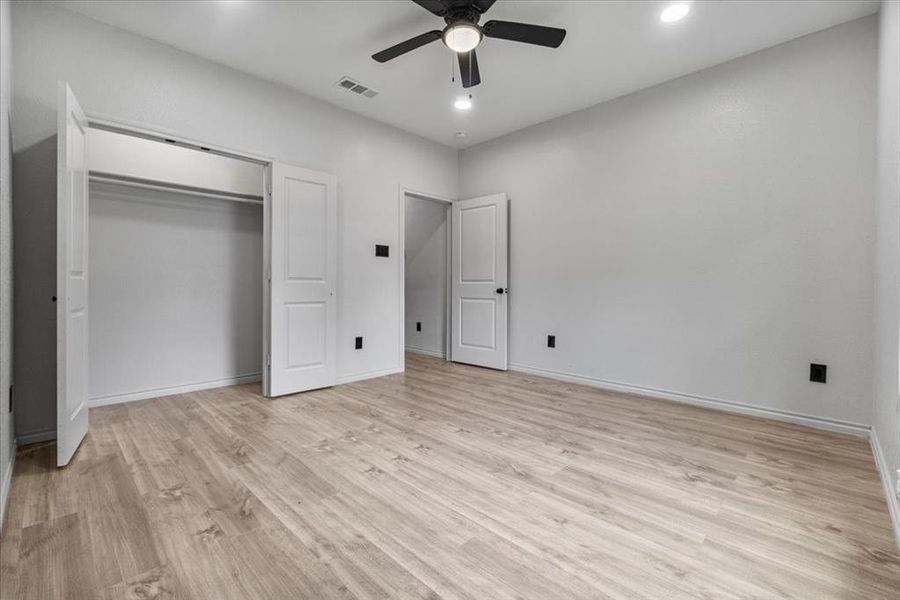 Unfurnished bedroom with ceiling fan, light hardwood / wood-style floors, and a closet