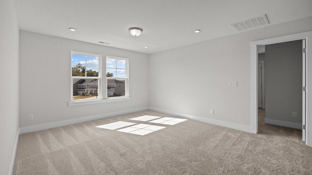 Burton Design bright and spacious bedroom with large windows at Lakeside Glen by premier builder DRB Homes in York, SC.