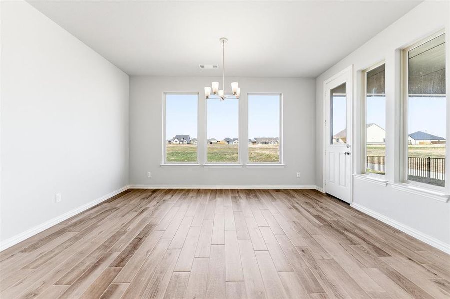 Unfurnished dining area with light wood finished floors and a chandelier