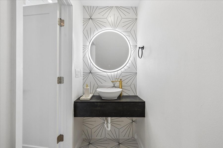 Designer powder bath featuring a floating vanity, statement wall tile, and contemporary fixtures. Designer powder bath featuring a floating vanity, statement wall tile, and contemporary fixtures.