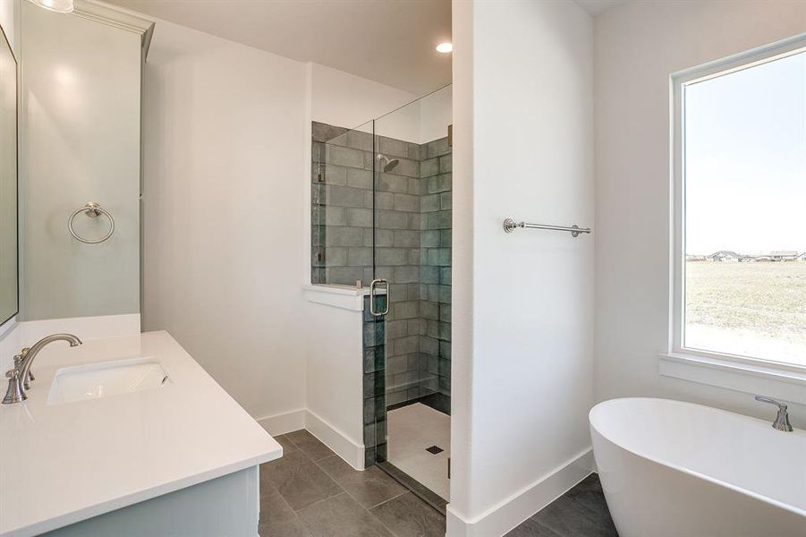 Bathroom with a soaking tub, a stall shower, vanity, dark tile patterned floors, and recessed lighting Bathroom with a soaking tub, a stall shower, vanity, dark tile patterned floors, and recessed lighting