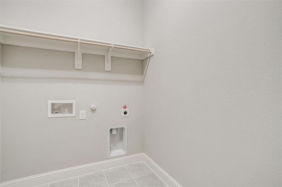 Clothes washing area with hookup for a washing machine, hookup for an electric dryer, hookup for a gas dryer, and tile patterned floors