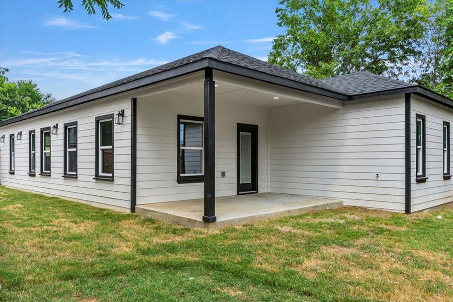 Back of property with a yard and a patio