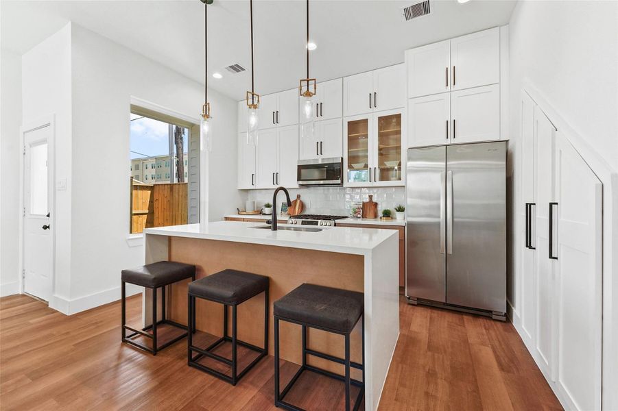 white cabinetry, warm wood accents, quartz countertops, a stylish tile backsplash, and a large island with pendant lighting—perfect for both cooking and entertaining. white cabinetry, warm wood accents, quartz countertops, a stylish tile backsplash, and a large island with pendant lighting—perfect for both cooking and entertaining.