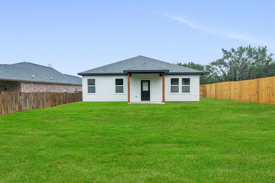 Rear view of property featuring a yard