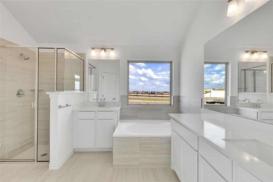 Full bathroom with a shower stall, two vanities, a bath, and vaulted ceiling Full bathroom with a shower stall, two vanities, a bath, and vaulted ceiling