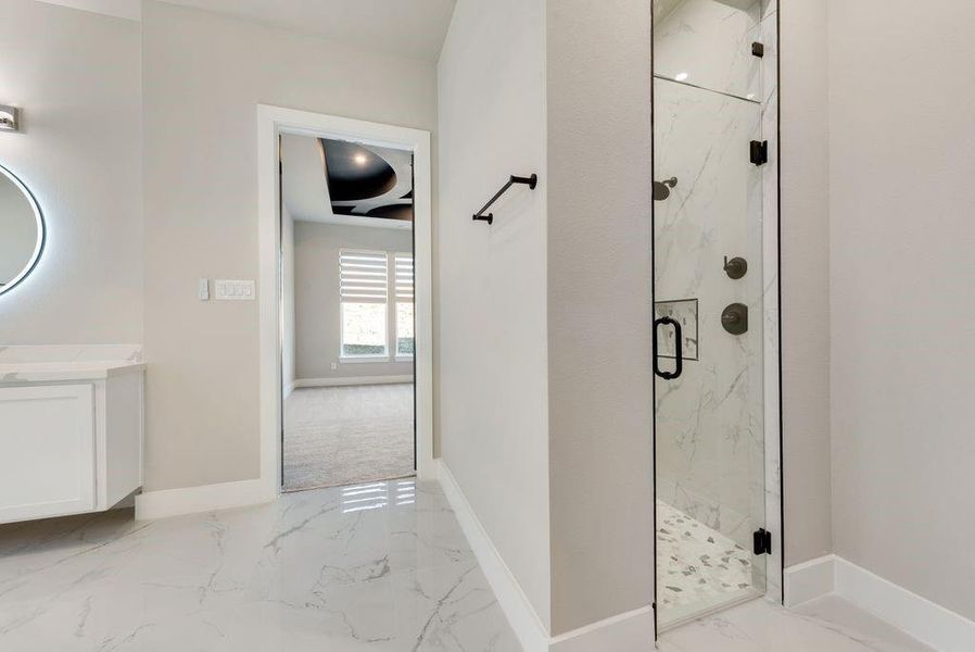 Bathroom featuring a shower with door and vanity