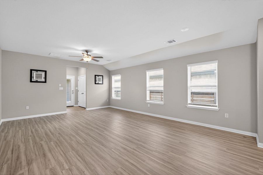 Unfurnished room with vaulted ceiling, ceiling fan, and light wood-style flooring
