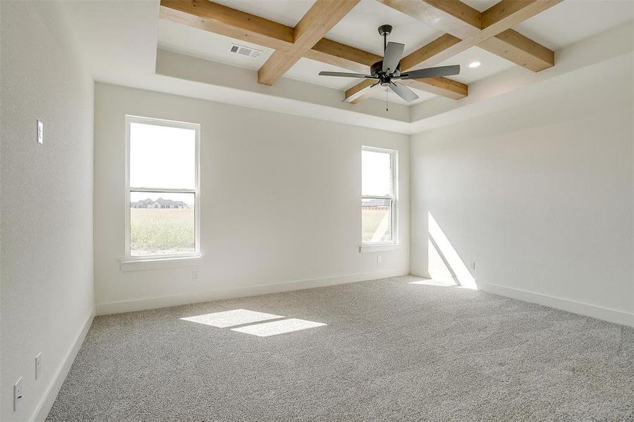 Spare room with beam ceiling, a healthy amount of sunlight, and ceiling fan