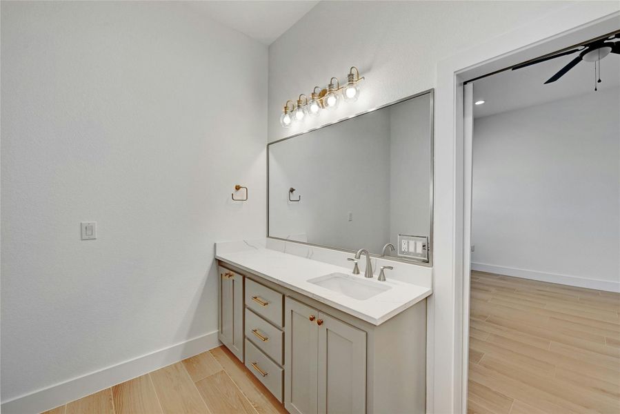 Double vanity sinks with large mirrors and gorgeous lighting fixtures.