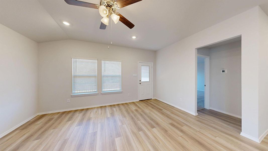 Living area featuring wood-finish flooring, vaulted ceiling, and recessed lighting