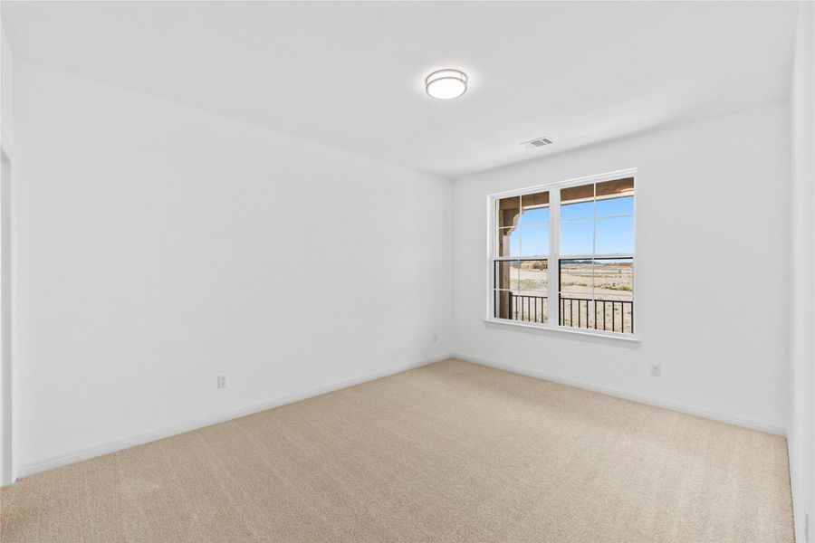 Carpeted spare room with baseboards