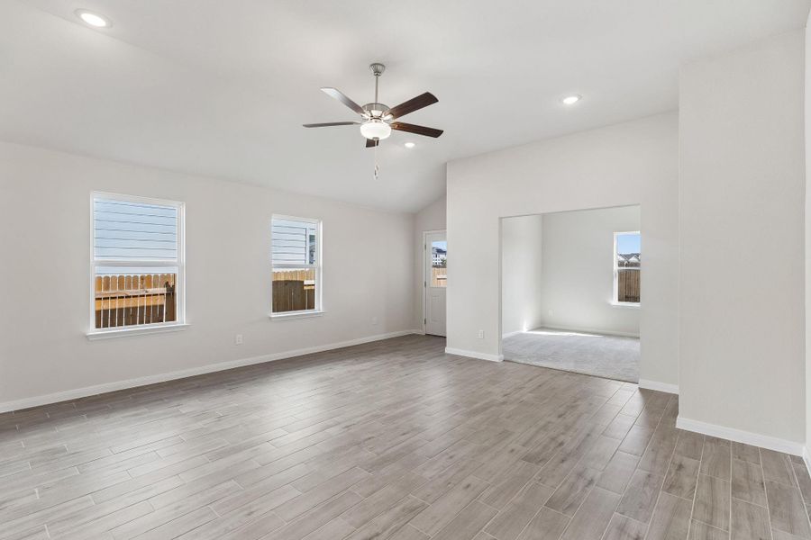 Open archway defines this versatile living space under vaulted ceilings.