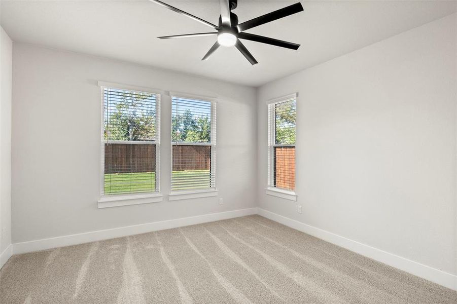 Empty room with carpet flooring and a ceiling fan