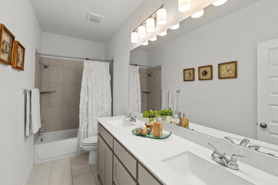 A spacious double vanity and tile flooring define this modern bathroom space.