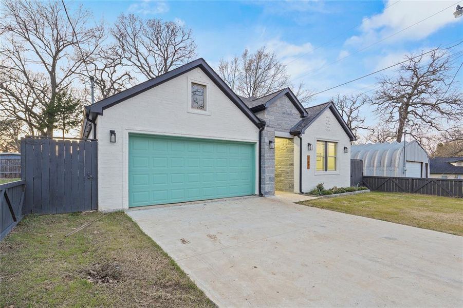 View of front facade featuring concrete driveway, brick siding, a garage, and stone siding