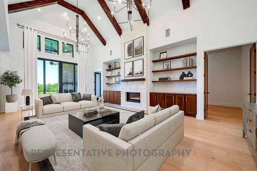 Living area with high vaulted ceiling, light wood-type flooring, a stone fireplace, beam ceiling, and built in shelves Living area with high vaulted ceiling, light wood-type flooring, a stone fireplace, beam ceiling, and built in shelves