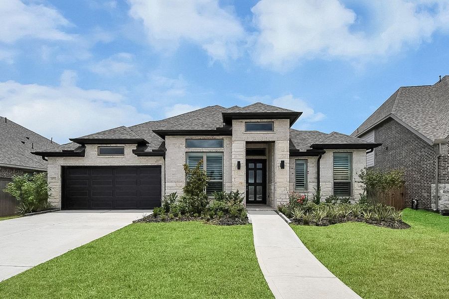 Front exterior of a new home in Valencia, Manvel, TX, highlighting curb appeal (Image 1). Front exterior of a new home in Valencia, Manvel, TX, highlighting curb appeal (Image 1).