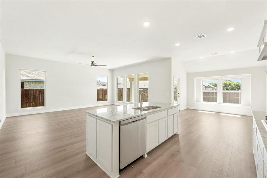 Open-concept living space featuring wood-finish flooring, recessed lighting, and a contemporary ceiling fan Open-concept living space featuring wood-finish flooring, recessed lighting, and a contemporary ceiling fan