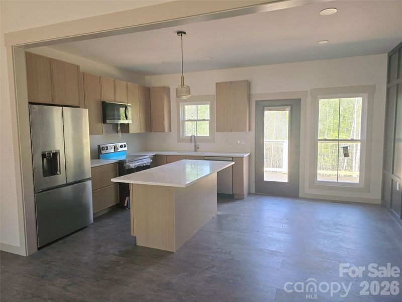 White Oak kitchen cabinets with quartz countertops and stainless appliances