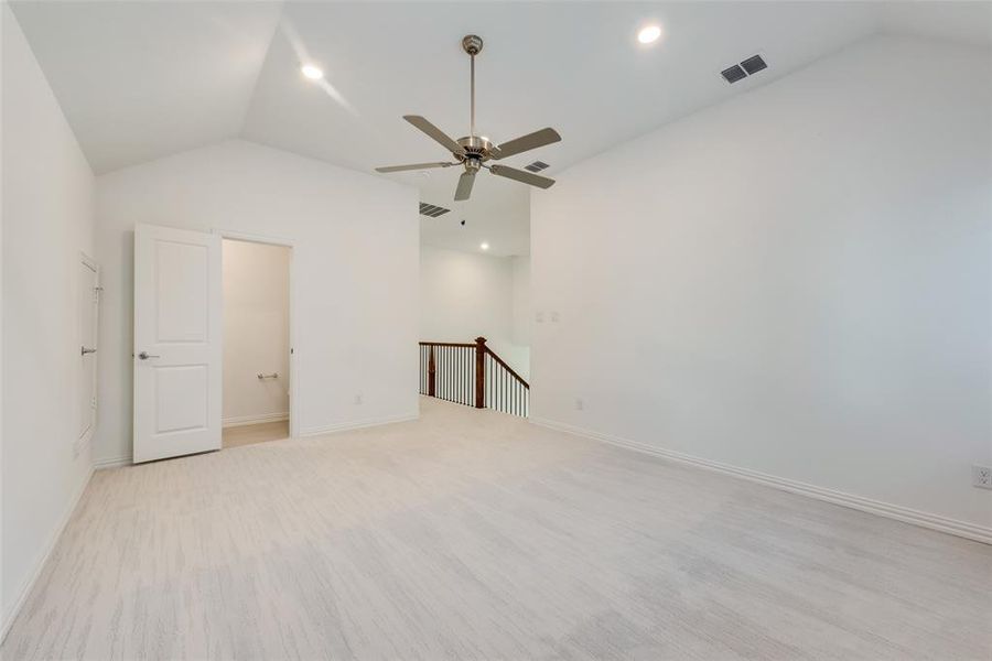 Unfurnished bedroom with ceiling fan and lofted ceiling