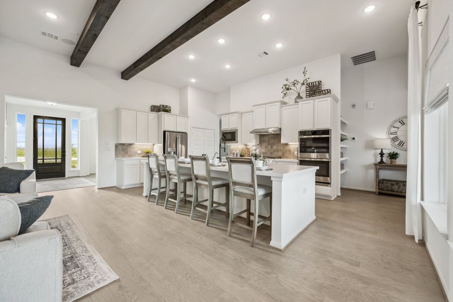 Kitchen adjacent to great room with optional stained ceiling beams Kitchen adjacent to great room with optional stained ceiling beams
