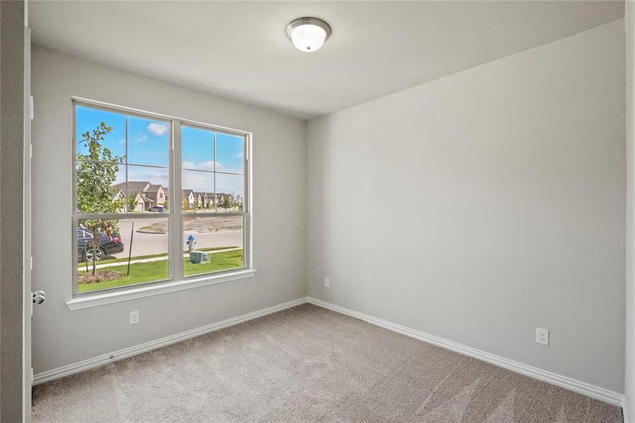 Carpeted spare room featuring a healthy amount of sunlight
