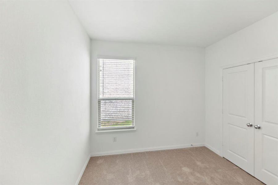 Unfurnished bedroom with light colored carpet and a closet