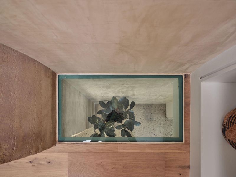 This structural glass element offers an elegant and playful wayto introduce natural light into an otherwise dim hallway.Directing the flow of daylight here highlights the intersection oframmed earth and the limed washed walls —two materialsbrought to life in this modern space. The result reveals the depth, richness, and subtle movementwithin each surface, transforming a transitional space into something that feels special and timeless. This structural glass element offers an elegant and playful wayto introduce natural light into an otherwise dim hallway.Directing the flow of daylight here highlights the intersection oframmed earth and the limed washed walls —two materialsbrought to life in this modern space. The result reveals the depth, richness, and subtle movementwithin each surface, transforming a transitional space into something that feels special and timeless.