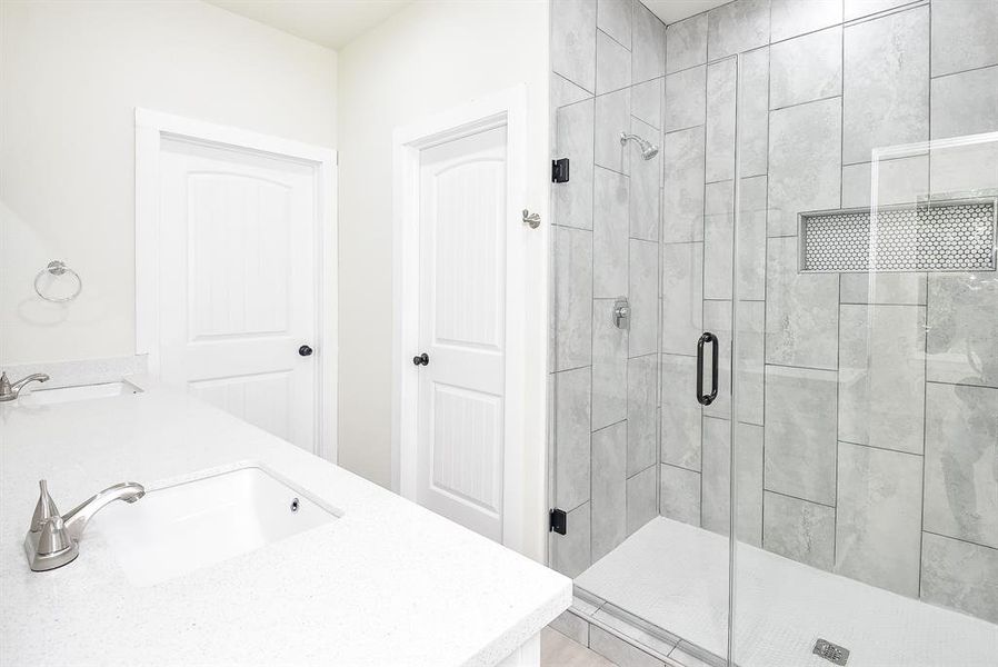 Primary En-Suite Bathroom with Double Sinks, Walk-In Closet and Large Shower.