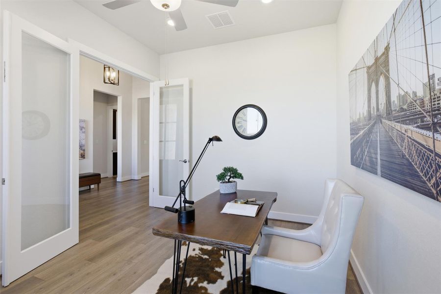 Home office featuring french doors, wood finished floors, and a ceiling fan