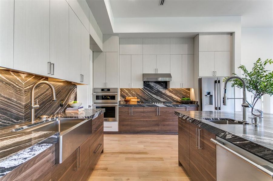 Kitchen with white cabinetry, light hardwood / wood-style flooring, stainless steel appliances, and sink