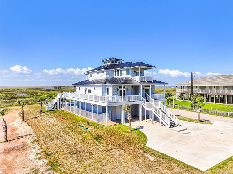 Coastal architecture and elevated outdoor living spaces come together beautifully in this striking exterior view. The home was thoughtfully designed to maximize scenery, comfort, and privacy.