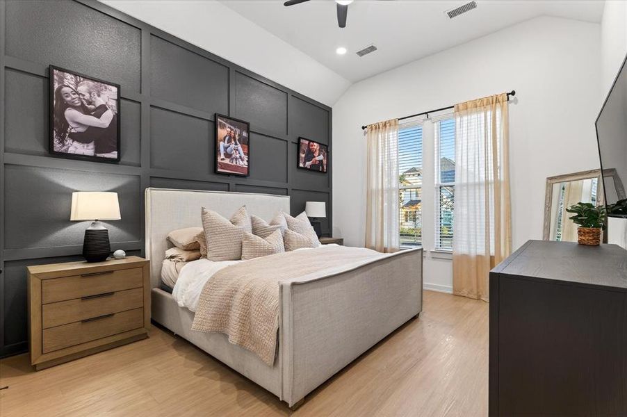 Bedroom featuring a decorative wall, vaulted ceiling, light wood finished floors, a ceiling fan, and recessed lighting Bedroom featuring a decorative wall, vaulted ceiling, light wood finished floors, a ceiling fan, and recessed lighting
