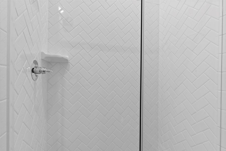 Modern walk-in shower with striking tile surround, offering a clean and refreshing design.