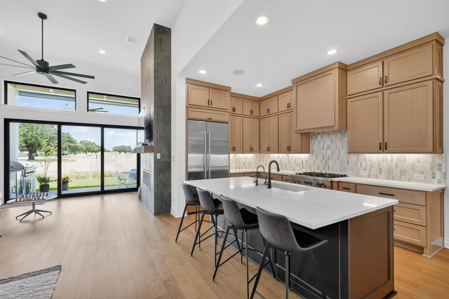 An open concept design seamlessly integrates the chef's kitchen with a generous living area, offering picturesque outdoor views. An open concept design seamlessly integrates the chef's kitchen with a generous living area, offering picturesque outdoor views.