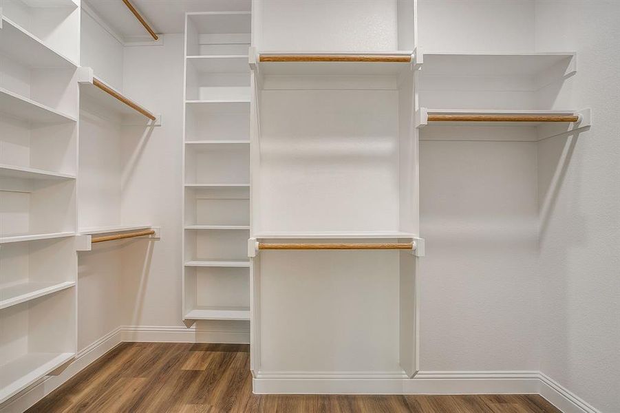 Walk in closet with dark wood-type flooring