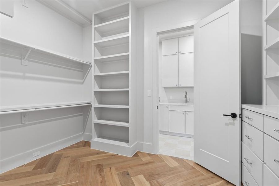 Primary closet with floor-to-ceiling shelving, double hang rods, built-in dresser, and pass-through to laundry Primary closet with floor-to-ceiling shelving, double hang rods, built-in dresser, and pass-through to laundry