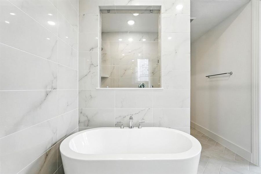 Bathroom featuring a freestanding bath, tile patterned flooring, tile walls, and recessed lighting Bathroom featuring a freestanding bath, tile patterned flooring, tile walls, and recessed lighting