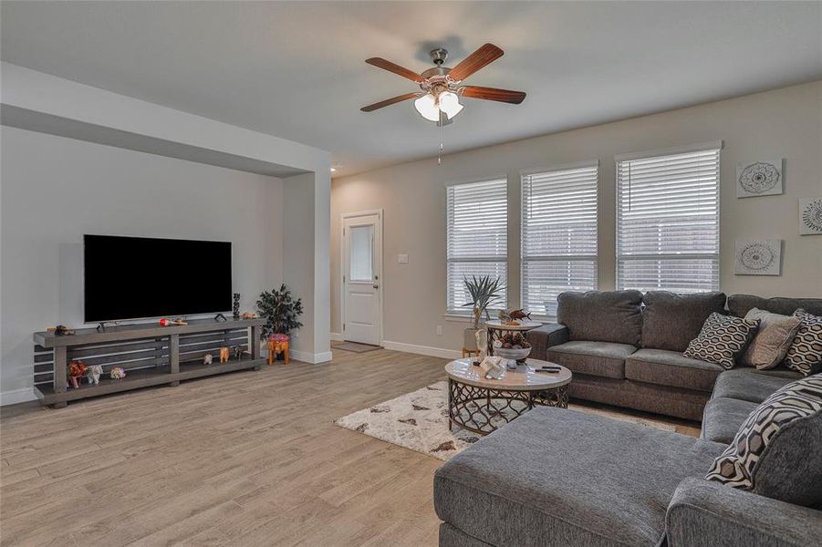 Living area featuring wood finished floors and a ceiling fan Living area featuring wood finished floors and a ceiling fan