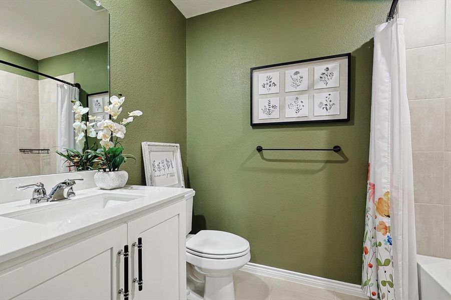 Full bathroom featuring vanity, shower / tub combo, tile patterned flooring, and toilet