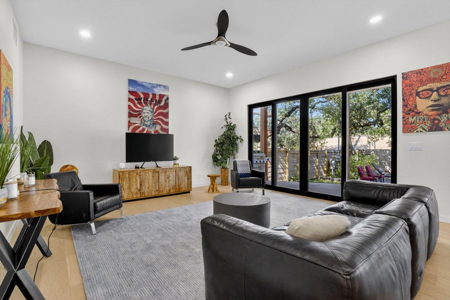 Living area featuring a ceiling fan, light wood-style flooring, and recessed lighting