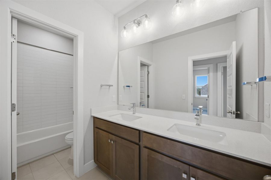 Double vanities with sleek countertops and abundant lighting create a functional and aesthetically pleasing space.