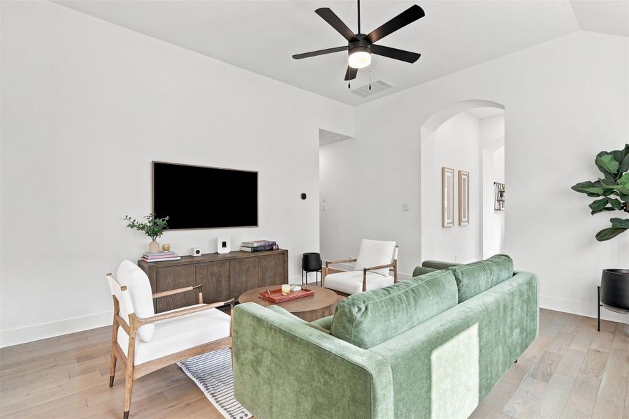 Smooth wood floors and vaulted ceilings elevate this open, airy gathering space.
