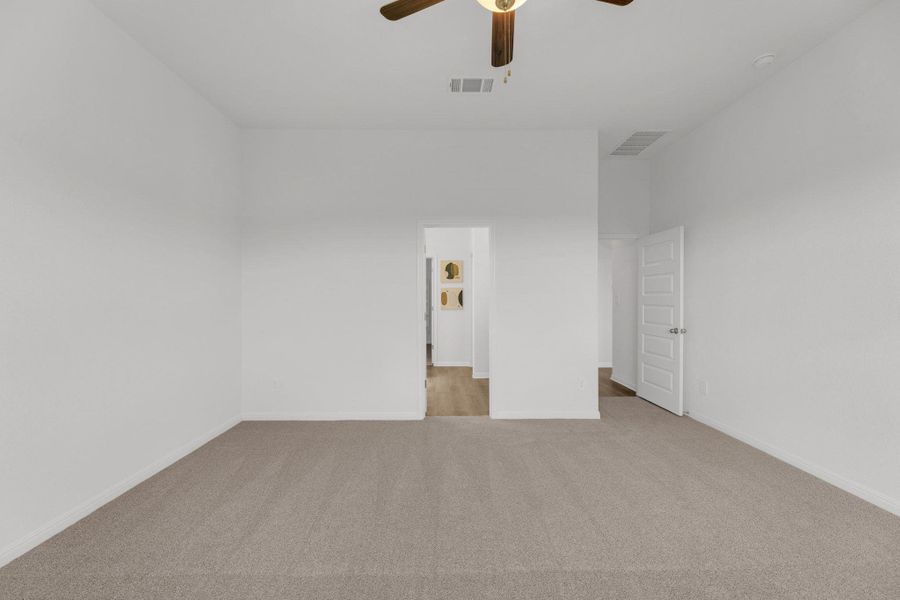 Unfurnished bedroom with light colored carpet and a ceiling fan Unfurnished bedroom with light colored carpet and a ceiling fan