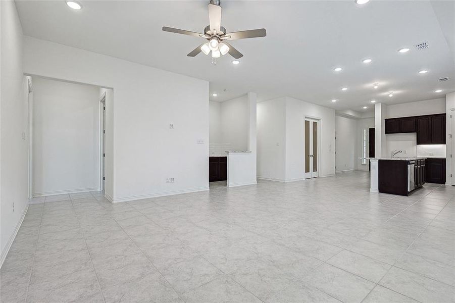 Unfurnished living room with ceiling fan and sink